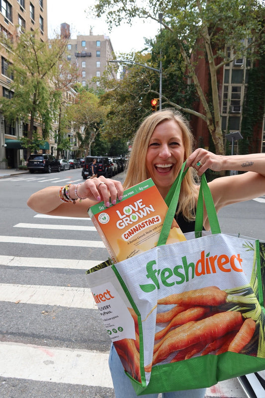 Love Grown Co-Founder Katie Tyson holding Love Grown cereal in a Fresh Direct bag