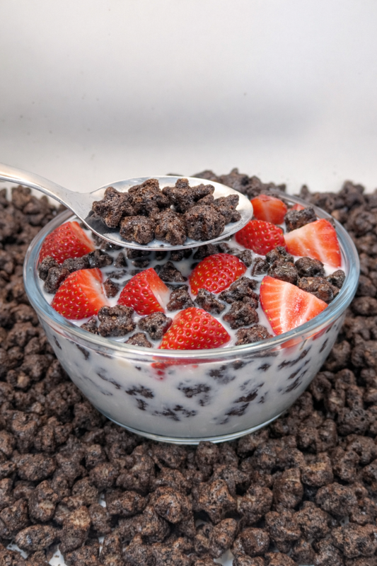 chocolate cereal in a bowl with milk and strawberries