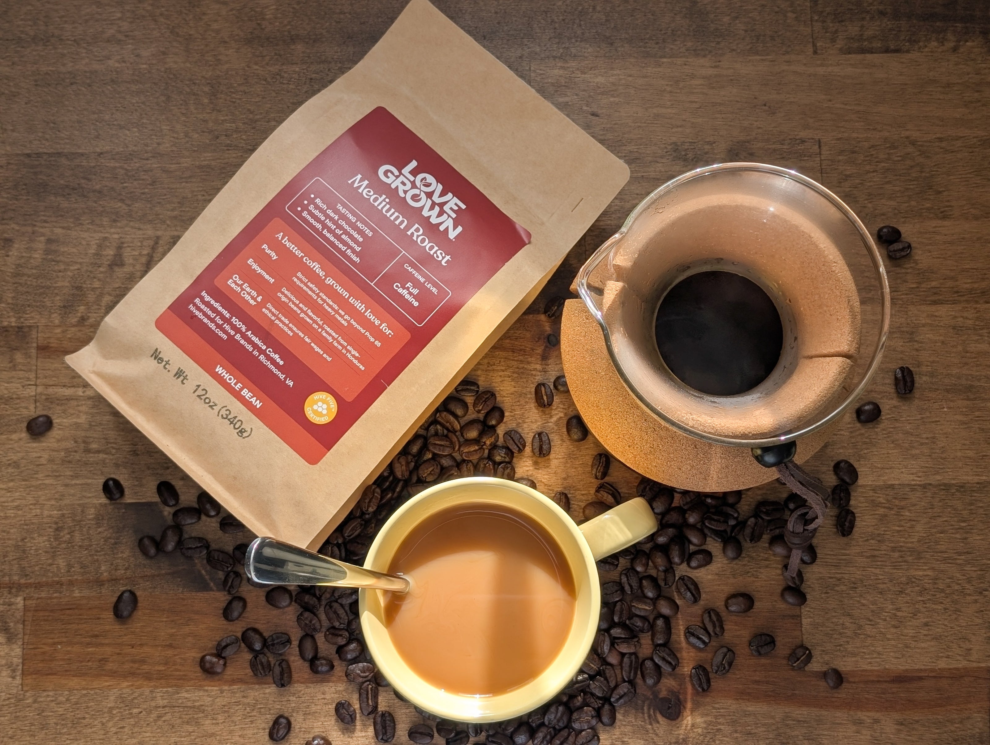 Two coffee cups with a bag of coffee beans on a wooden surface
